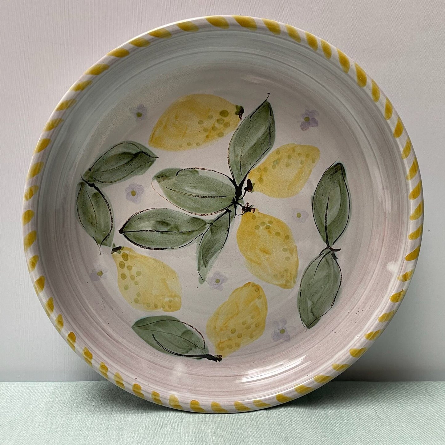 Ceramic plate with lemon design on a plain background